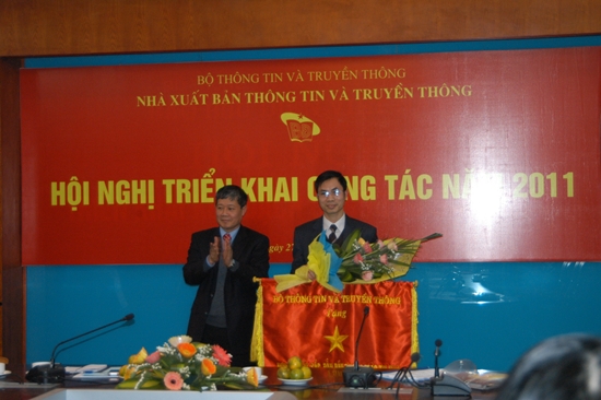 Thứ trưởng Nguyễn Thành Hưng thay mặt Bộ trưởng tặng cờ thi đua của Bộ TT&TT cho đại diện Ban biên tập sách Kinh tế - Chính trị - Xã hội NXB TTTT.
