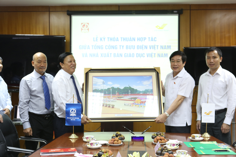 Bộ trưởng Nguyễn Bắc Son trao tặng bức tranh lưu niệm cho Nhà xuất bản giáo dục.