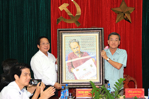 Chủ tịch UBND tỉnh Đinh Quốc Thái tiếp nhận ảnh Bác Hồ đọc Báo Nhân Dân do Bộ trưởng Bộ Thông tin và truyền thông Trương Minh Tuấn trao tặng