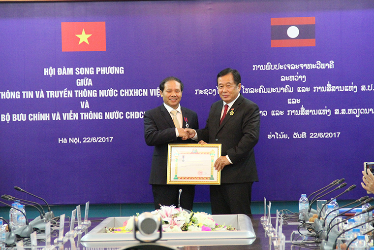   Bộ trưởng Bộ Bưu chính và Viễn thông Lào Thansamay Kommashith trao Huân chương Lao động hạng Nhì cho ông Đoàn Quang Hoan, Cục trưởng Cục Tần số Vô tuyến điện.